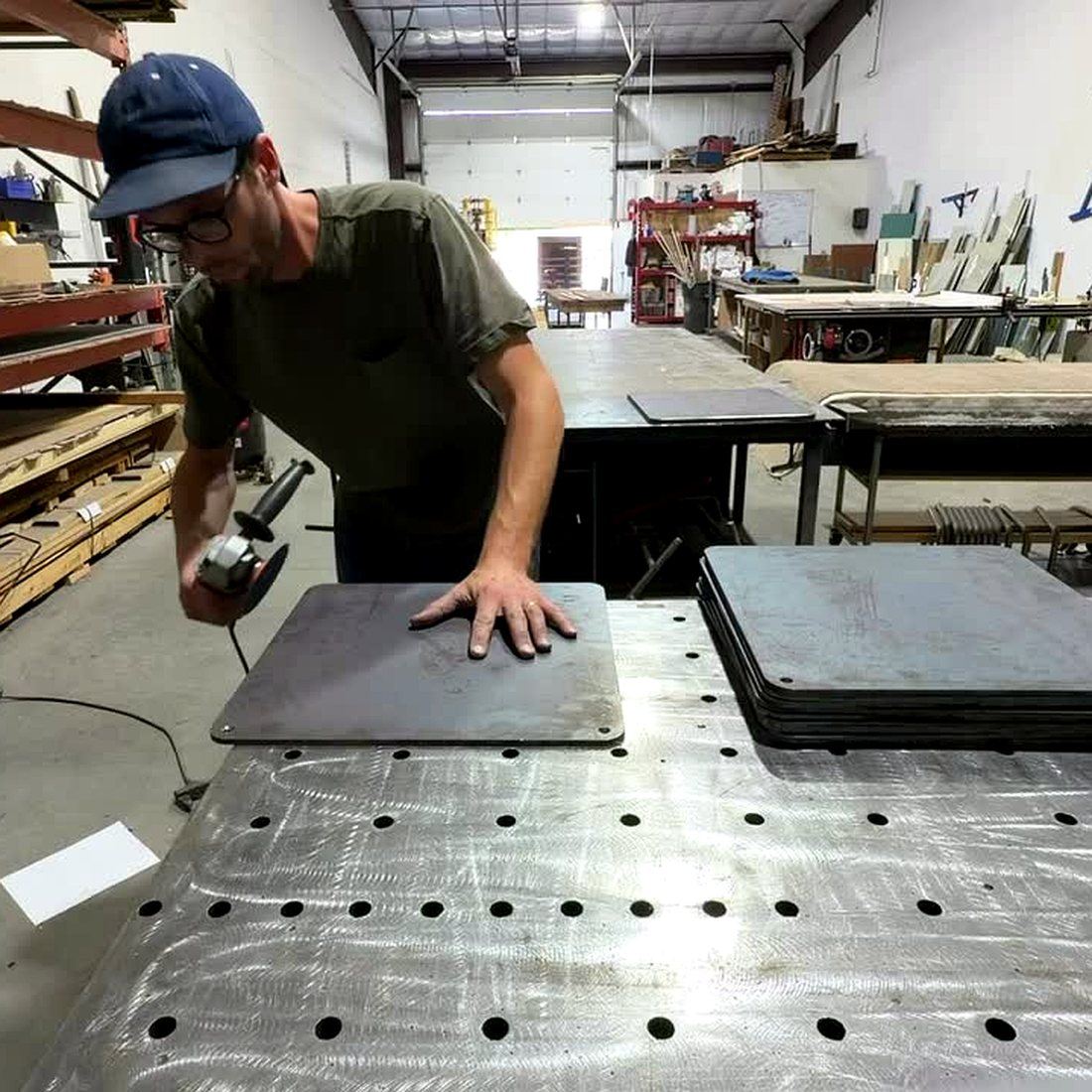 Scott finishing a pizza steel by hand in his shop